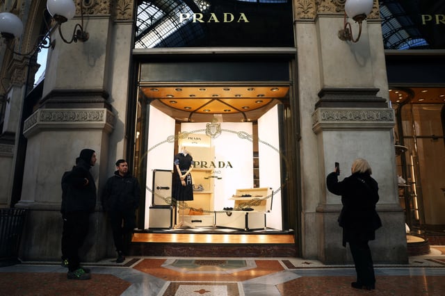 People stand outside a Prada store in Galleria Vittorio Emanuele II in Milan, Italy, January 10, 2025. REUTERS/Claudia Greco/File Photo