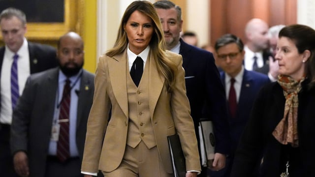 First lady Melania Trump walks through the Capitol wearing a three-piece tan suit. 