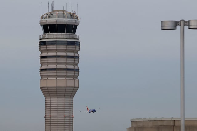 A plane flies next to an air traffic control near Ronald Reagan Washington National Airport in Arlington, Virginia, U.S., January 30, 2025. REUTERS/Evelyn Hockstein/File Photo