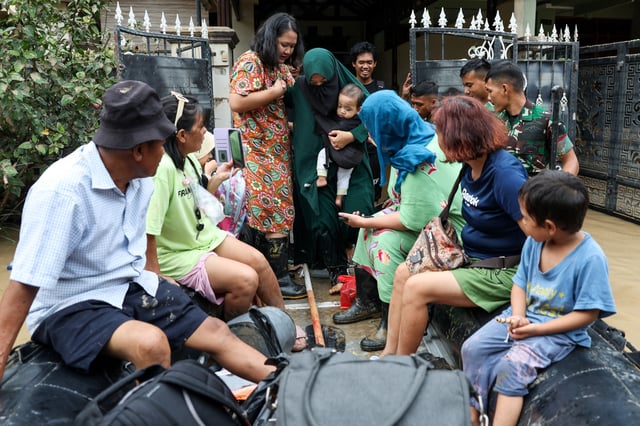 People evacuate from a flooded residential area following heavy rains in Bekasi, on the outskirts of Jakarta, Indonesia, March 4, 2025. REUTERS/Ajeng Dinar Ulfiana