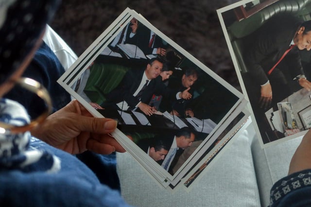 Faiza Rahem, the wife of detained Tunisian politician Issam Chebbi, shows pictures of her husband, during an interview with Reuters at her home in Tunis, Tunisia August 7, 2024. REUTERS/Staff/File Photo