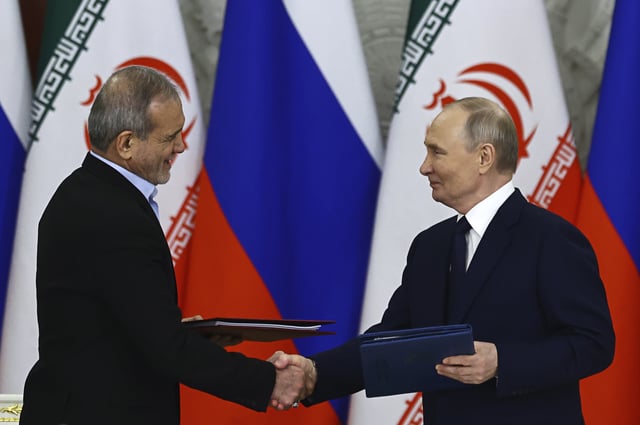 Russian President Vladimir Putin, right, and Iranian President Masoud Pezeshkian attend a signing ceremony at the Kremlin in Moscow, Russia, Friday, Jan. 17, 2025.