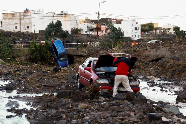The owner of a damaged car inspects his vehicle after it was swept away by the rain in the Las Bachilleras ravine, in Telde, Gran Canaria
(Photo: Borja Suarez/Reuters)