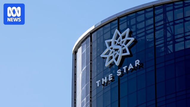 The side of a high-rise building with a pointed star logo with the words "The Star" below against a clear blue sky.