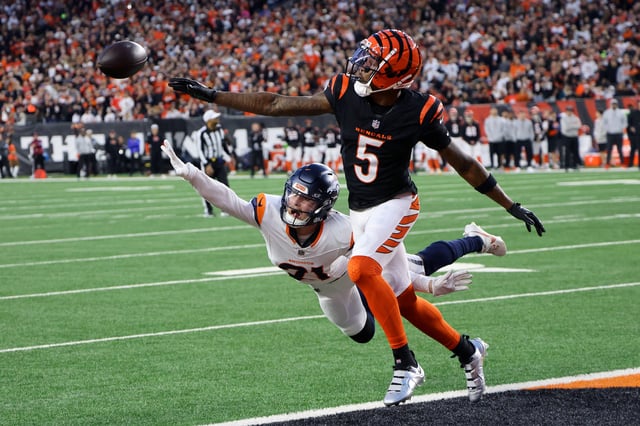 Dec 28, 2024; Cincinnati, Ohio, USA;  Cincinnati Bengals wide receiver Tee Higgins (5) goes for the football against Denver Broncos cornerback Riley Moss (21) during the second quarter at Paycor Stadium. Mandatory Credit: Joseph Maiorana-Imagn Images/File Photo