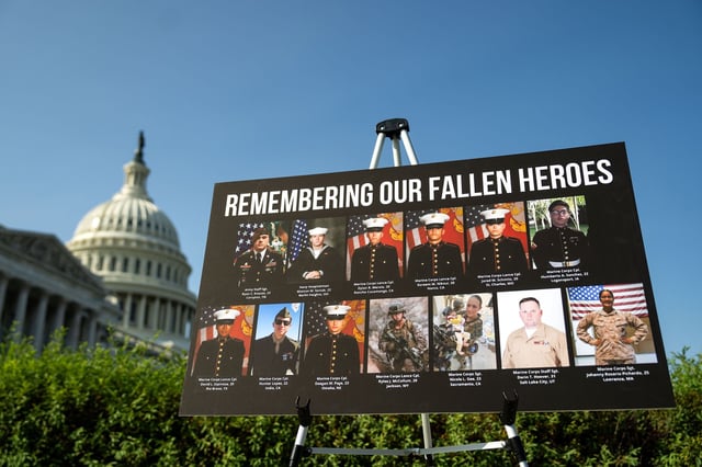 A sign displaying photos and names of the 13 service members killed in a terrorist attack at Abbey Gate outside Kabul's Hamid Karzai International Airport is seen during a news conference at the U.S. Capitol on September 9, 2024 in Washington, DC.