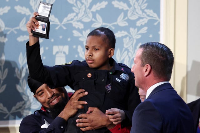 Cancer survivor Devarjaye "DJ" Daniel gestures as he is made an honorary Secret Service agent on the day of U.S. President Donald Trump's speech to a joint session of Congress, in the House Chamber of the U.S. Capitol in Washington, D.C., U.S., March 4, 2025. REUTERS/Kevin Lamarque