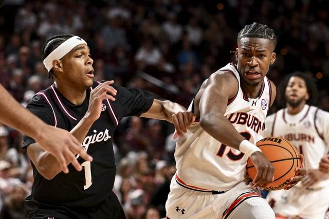 Mar 4, 2025; College Station, Texas, USA; Auburn Tigers guard Miles Kelly (13) drives against Texas A&M Aggies guard Zhuric Phelps (1) during the second half at Reed Arena. Mandatory Credit: Maria Lysaker-Imagn Images