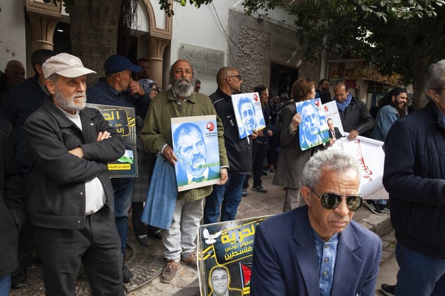 Protesters hold photos of detainees during a gathering outside the courthouse in Tunis, Tuesday, March 4, 2025, demanding the release of individuals prosecuted in a case of conspiracy against state security. (AP Photo/Ons Abid)