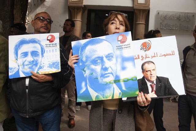 Protesters hold photos of detainees during a gathering outside the courthouse in Tunis, Tuesday, March 4, 2025, demanding the release of individuals prosecuted in a case of conspiracy against state security. (AP Photo/Ons Abid)