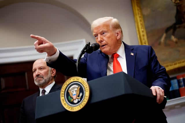 President Donald Trump, accompanied by Commerce Secretary Howard Lutnick (L) takes a question from a reporter in the Roosevelt Room of the White House on March 3, 2025 in Washington, DC.