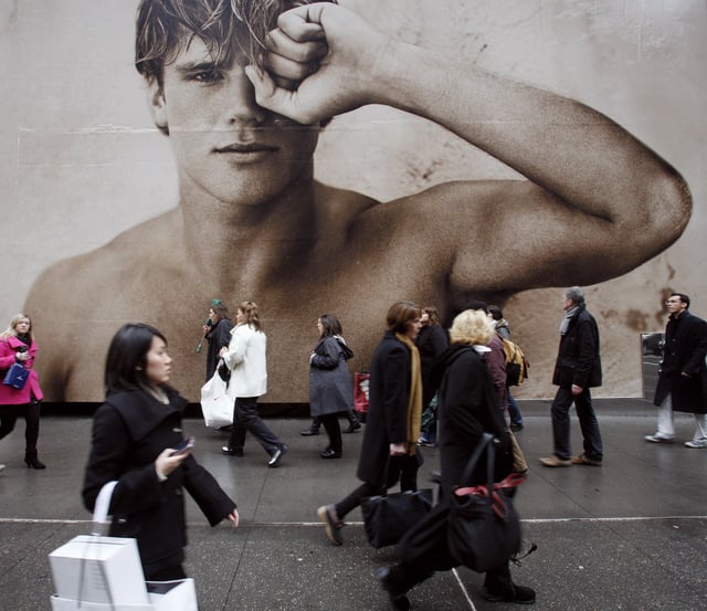 FILE - In this photo made Dec. 9, 2009, shoppers walk past a billboard for an Abercrombie & Fitch store in New York. (AP Photo/Mark Lennihan, file)