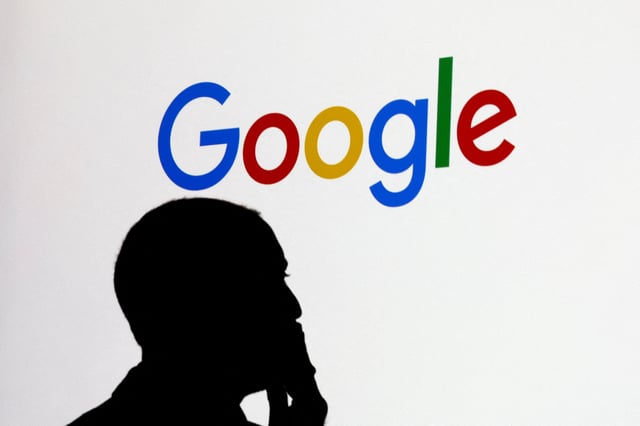 A man stands in front of a Google logo during a media reception at the Google France headquarters ahead of the Artificial Intelligence Action Summit in Paris, France, February 9, 2025. REUTERS/Gonzalo Fuentes/File Photo
