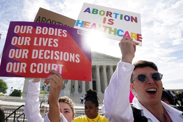 Abortion rights supporters hold placards on the day the Supreme Court justices hear oral arguments over the legality of Idaho's Republican-backed, near-total abortion ban in medical-emergency situations, at the U.S. Supreme Court in Washington, U.S., April 24, 2024.