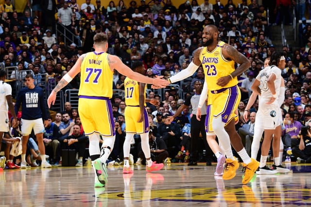 Luka Dončić (#77) and LeBron James (#23) of the Los Angeles Lakers high five during the game against the Minnesota Timberwolves on February 27, 2025, at Crypto.Com Arena in Los Angeles, California.