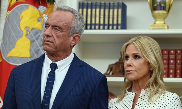 Robert F. Kennedy Jr. (L) and his wife Cheryl Hines listen to US President Donald Trump before a swearing in ceremony for Kennedy as Secretary of Health and Human Services in the Oval Office of the White House in Washington, DC, on February 13, 2025. (Photo by ANDREW CABALLERO-REYNOLDS / AFP) (Photo by ANDREW CABALLERO-REYNOLDS/AFP via Getty Images)