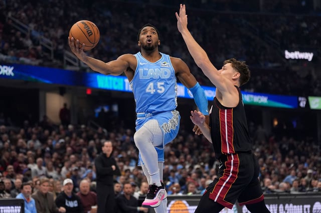 Cleveland Cavaliers guard Donovan Mitchell goes to the basket past Miami Heat guard Pelle Larsson, right, in the first half of an NBA basketball game in Cleveland, Ohio, on Wednesday, March 5, 2025.