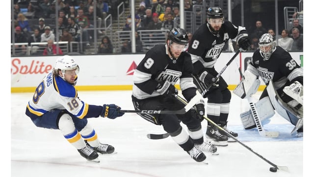 Kings right wing Adrian Kempe moves the puck away from St. Louis Blues center Robert Thomas during the third period on Wednesday night at Crypto.com Arena. The Blues won, 3-2, in a shootout. (AP Photo/Jae C. Hong)