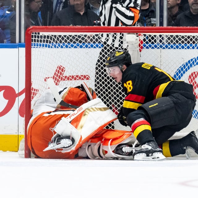 Vancouver Canucks' Drew O'Connor (18) gets up after falling into Anaheim Ducks goaltender John Gibson, left, during the second period of an NHL hockey game in Vancouver, B.C., on Wednesday, March 5, 2025. THE CANADIAN PRESS/Ethan Cairns