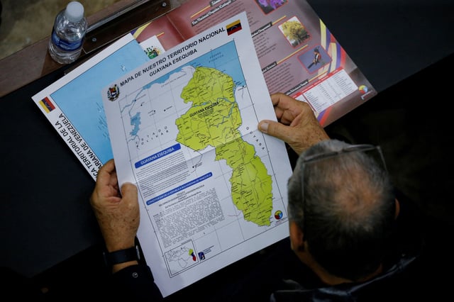 A member of the National Assembly of the Assembly holds a map showing the disputed Esequibo region as part of Venezuela, as tensions between the Venezuela and Guyana have ratcheted up in recent weeks over a long-running territorial dispute, in Caracas, Venezuela, December 6, 2023. REUTERS/Leonardo Fernandez Viloria/File Photo