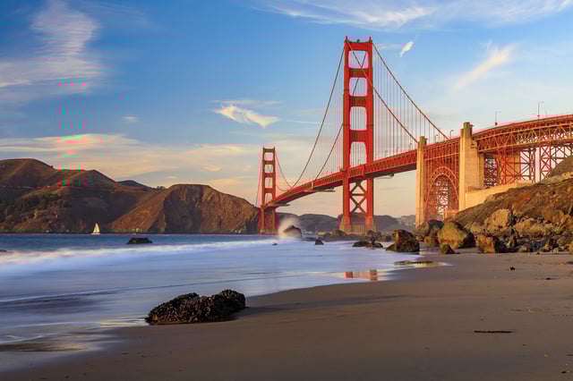 Famous Golden Gate Bridge view from the hidden and secluded rocky Marshall's Beach at sunset in San Francisco, California