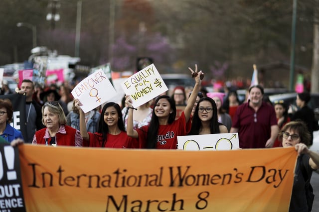 Demonstrators march during an International Women&#39;s Day rally in Atlanta, Wednesday, March 8, 2017. Around the country, people called on women to stay home from work and not spend money in stores or online to show their economic clout on America&#39;s fabric.