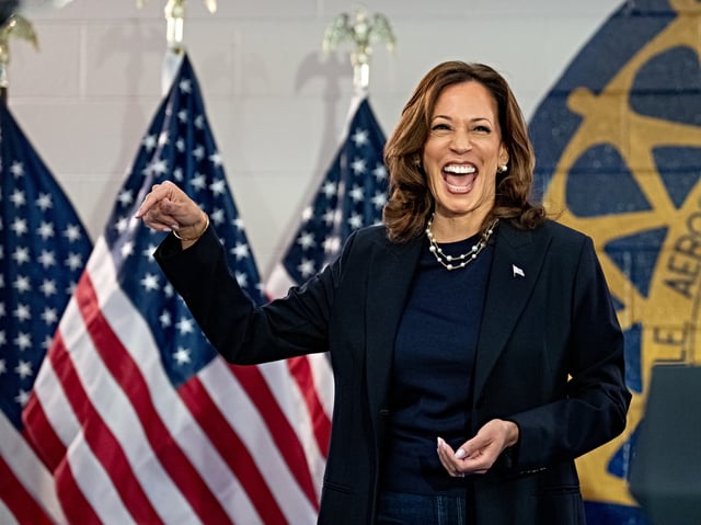 WAYNE, MICHIGAN - AUGUST 08: Democratic presidential candidate, U.S. Vice President Kamala Harris reacts as United Automobile Workers President Shawn Fain (R), speaks at a campaign rally at United Auto Workers Local 900 on August 8, 2024 in Wayne, Michigan. Kamala Harris and her newly selected running mate Tim Walz are campaigning across the country this week. (Photo by Andrew Harnik/Getty Images)