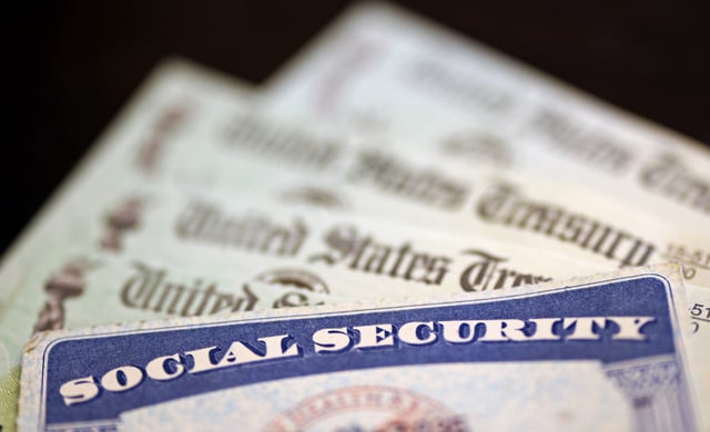 A Social Security card sits alongside checks from the U.S. Treasury on October 14, 2021 in Washington, D.C.
