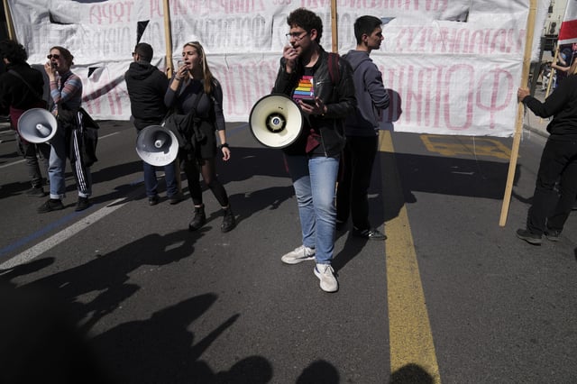 University students shout slogans using loudspeakers during a rally, on the third and final day of a censure motion debate against the conservative government in parliament over a deadly rail disaster nearly two years ago, in Athens, Greece, Friday, March 7, 2025. (AP Photo/Thanassis Stavrakis)