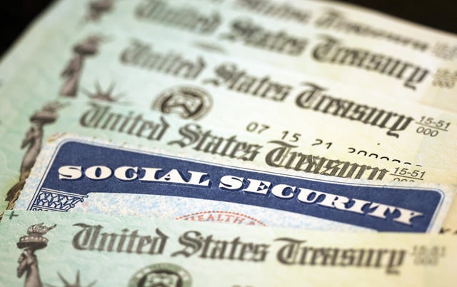 A a Social Security card sits alongside checks from the U.S. Treasury on October 14, 2021 in Washington, DC. The Social Security Administration announced recipients will receive an annual cost of living adjustment of 5.9%, the largest increase since 1982.