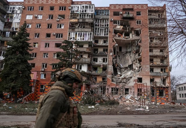 Un militaire ukrainien devant un immeuble résidentiel endommagé par une frappe russe dans la ville de Pokrovsk, dans la région de Donestk, le 6 mars 2025.