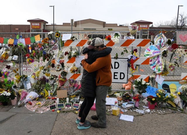 A couple embraces in front of the King Soopers on Table Mesa Drive March 26, 2021. Four days earlier, 10 people were killed in a mass shooting there, including a Boulder police officer. (Andy Cross/The Denver Post)