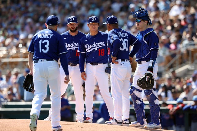 Manager Dave Roberts #30 of the Los Angeles Dodgers talks to Yoshinobu Yamamoto #18 before a pitching change during a spring training game against the Chicago Cubs at Camelback Ranch on February 20, 2025 in Glendale, Arizona.