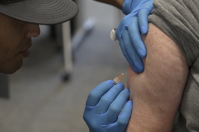 Matt Caldwell, left, a Lubbock Fire Department official, administers a measles, mumps and rubella vaccine to Clair May, 61, at the Lubbock Health Department, Wednesday, Feb. 26, 2025, in Lubbock, Texas.