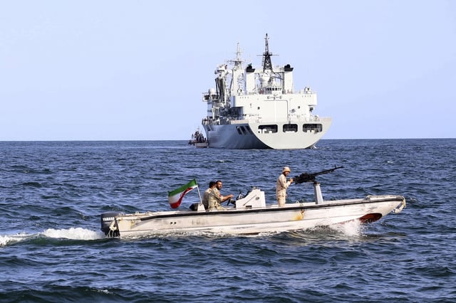 In this photo provided Tuesday, March 12, 2024, by the Iranian Army, an Iranian military boat patrols as a warship enters the Iranian waters prior to start of a joint naval drill of Iran, Russia and China in the Indian Ocean.