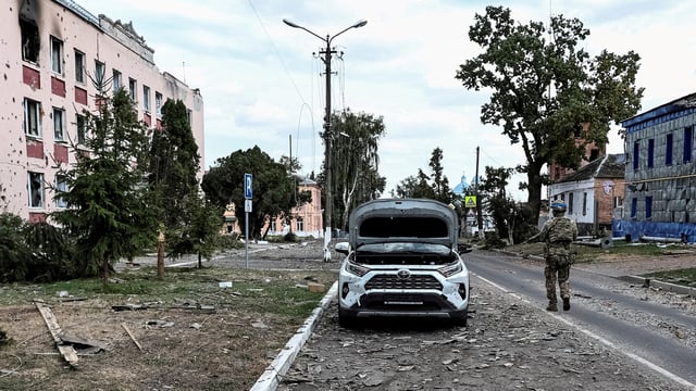 A Ukrainian serviceman patrols a street next to buildings damaged during recent fighting between Ukrainian and Russian forces in the Ukrainian-controlled town of Sudzha in Russia's Kursk region in August 2024.