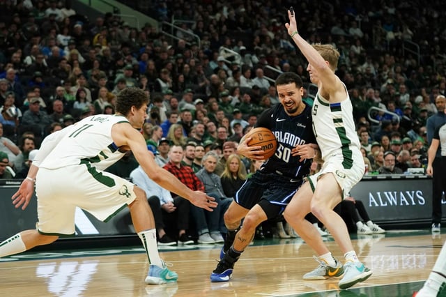 Orlando Magic&#39;s Cole Anthony (50) drives to the basket between Milwaukee Bucks&#39; Brook Lopez (11) and AJ Green, right, during the first half of an NBA basketball game Saturday, March 8, 2025, in Milwaukee. (AP Photo/Aaron Gash)