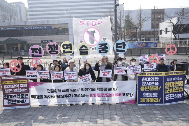 Protesters shout slogans during a press conference demanding to stop the upcoming Freedom Shield military exercise between the U.S. and South Korea, near the Defense Ministry in Seoul, South Korea, Monday, March 10, 2025. The letters read "Stop, War exercise." (AP Photo/Lee Jin-man)
