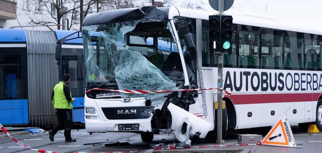 Ein Reisebus und eine Tram stehen nach einem Unfall auf der Straße