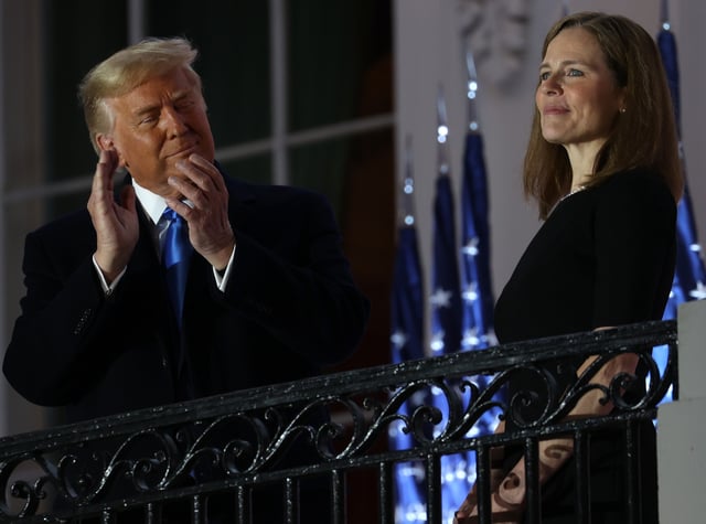 Donald Trump (left) stands with newly sworn in U.S. Supreme Court Associate Justice Amy Coney Barrett during a ceremonial swearing-in event on the South Lawn of the White House October 26, 2020 in Washington, DC.