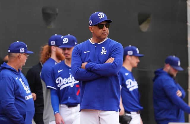 Los Angeles Dodgers manager Dave Roberts looks on during a Spring Training workout at Camelback Ranch.