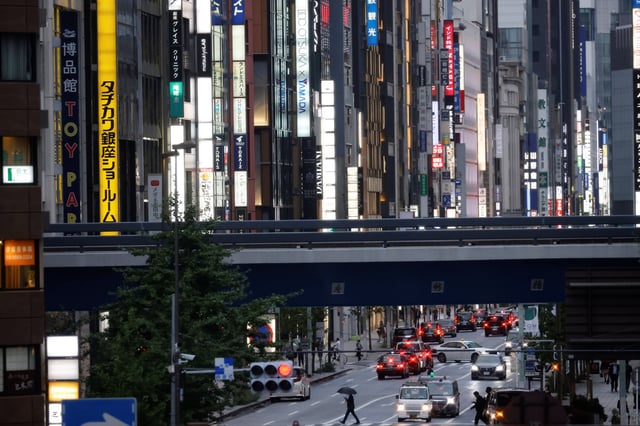 A man uses an umbrella while crossing an avenue during a rainy day near Shimbashi station in Tokyo, Japan, August 16, 2021. Picture taken August 16, 2021. REUTERS/Ivan Alvarado/File photo