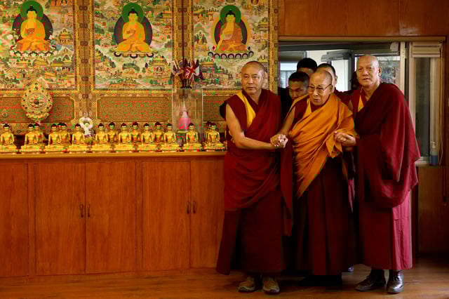 Tibetan spiritual leader, the Dalai Lama, is escorted into a hall by monks holding his hands at his Himalayan residence in Dharamshala, India, December 20, 2024. REUTERS/Priyanshu Singh/File Photo