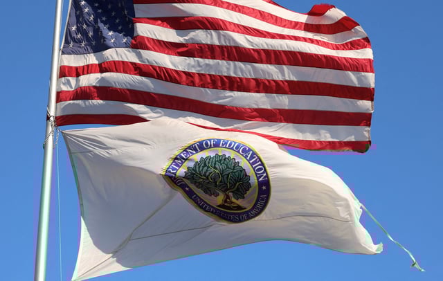 An American flag and a tattered U.S. Department of Education flag fly outside the federal office building in Washington, U.S., February 4, 2025. REUTERS/Kevin Lamarque/File Photo