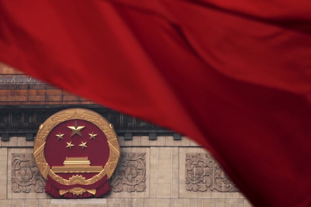 Red flags flutter in the wind near the Chinese national emblem outside the Great Hall of the People during the closing of the Chinese People's Political Consultative Conference in Beijing, Monday, March 10, 2025. (AP Photo/Andy Wong)