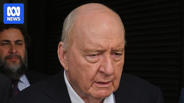 Alan Jones wearing a suit and tie