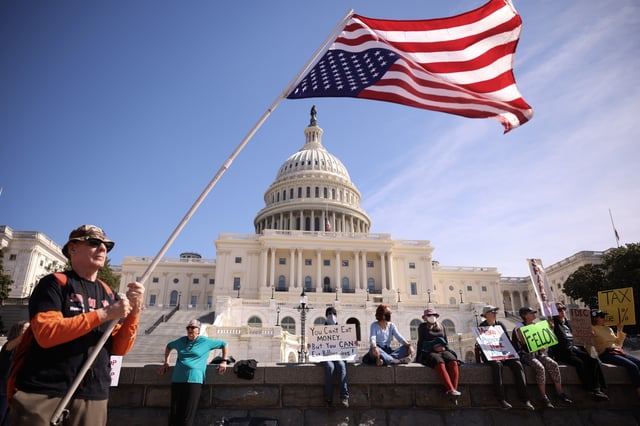 Michael Marceau (L) waves an upside-down American flag during the &#34;Shut Down the Coup&#34; protest on the West Lawn of the U.S. Capitol on March 10, 2025, in Washington, DC.