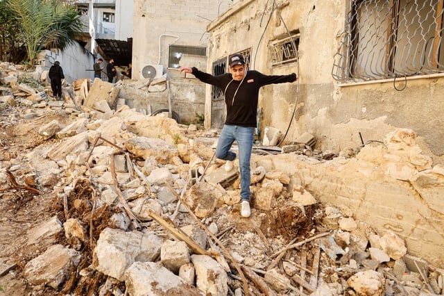 A man walks, near the site where a number of Palestinians were killed in an Israeli raid, in Jenin, in the Israeli-occupied West Bank, March 11, 2025. REUTERS/Raneen Sawafta