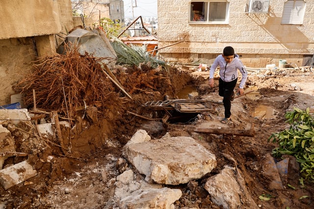 A boy walks, near the site where a number of Palestinians were killed in an Israeli raid, in Jenin, in the Israeli-occupied West Bank, March 11, 2025. REUTERS/Raneen Sawafta