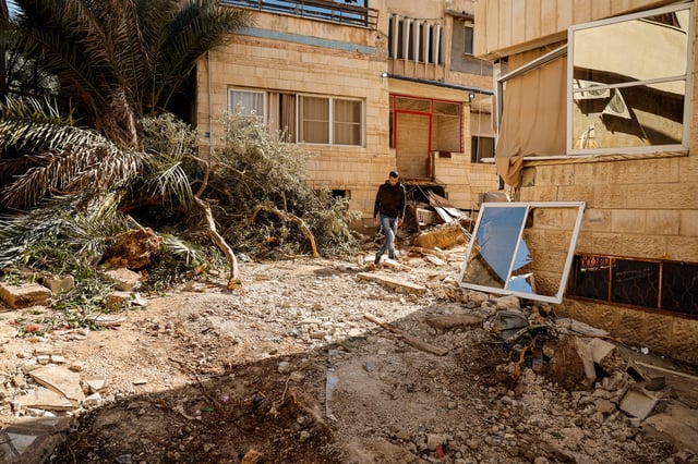 A man walks, near the site where a number of Palestinians were killed in an Israeli raid, in Jenin, in the Israeli-occupied West Bank, March 11, 2025. REUTERS/Raneen Sawafta